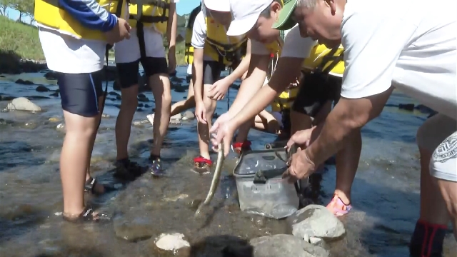 Children learn traditional Japanese eel fishing from elderly in local community