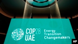 FILE - In a display, water flows onto a sign for Energy Transition Changemakers at the COP28 U.N. Climate Summit, in Dubai, United Arab Emirates, Dec. 5, 2023.