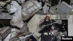 A rescuer works at a site of an apartment building hit by a Russian air strike, amid Russia's attack on Ukraine, in Kharkiv, Ukraine October 31, 2024.