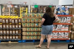 FILE - A shopper considers a purchase in a Costco warehouse in Parker, Colorado, Aug. 22, 2024.