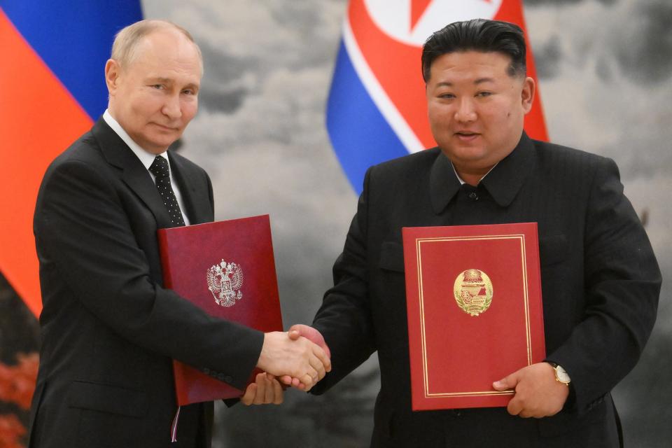 Putin shakes hands with Kim Jong Un