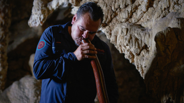 Josh Whiteland playing the didgeridoo at the Ngilgi Cave (Image credit: Tourism Western Australia)