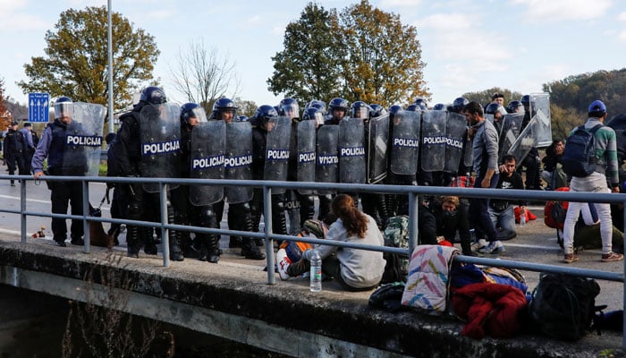 Croatian riot police stand guard in front of migrants at Maljevac border crossing between Bosnia and Croatia near Velika Kladusa, Bosniaon   on October 24, 2018. — Reuters