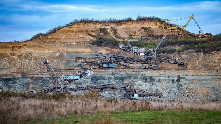 Coal extraction equipment operates at the open air quarry outside...