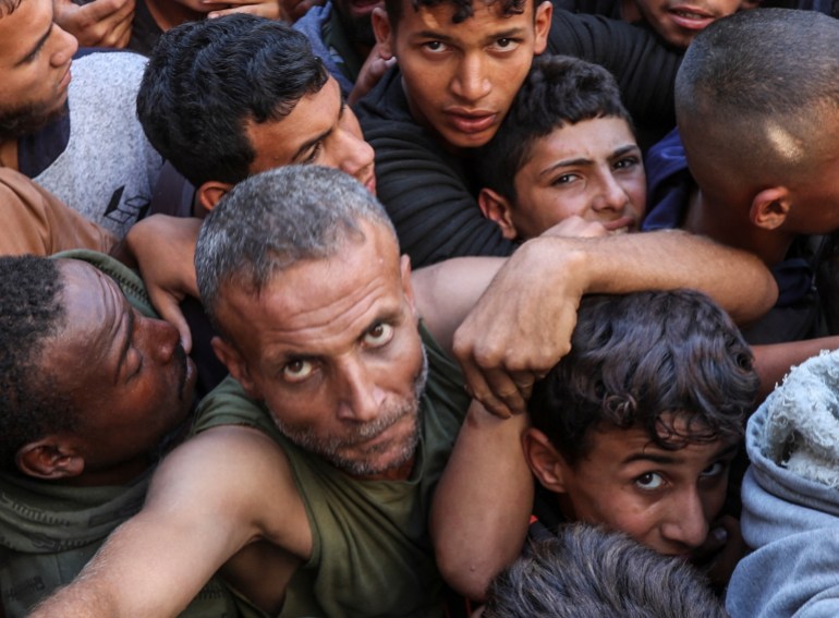 Palestinians gather to buy bread from a bakery, amid the Israel-Hamas conflict, in Deir Al-Balah