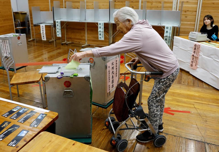 The 101-year-old Utako Kanayama casts her ballot in the general election at a polling station