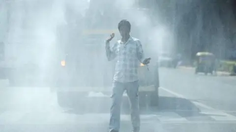 Getty Images A vehicle sprays water onto the road for dust suppression in New Delhi, India, on Tuesday