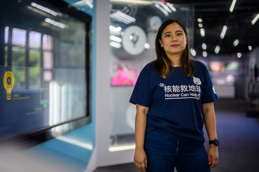 A woman with long hair, blue shirt that says Nuclear Can Help