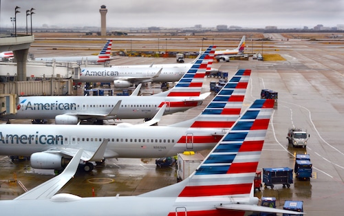 American Airlines jets parked at gates at Dallas Fort Worth International Airport on rainy day