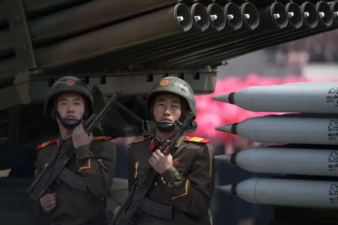 Members of the Korean People's Army (KPA) ride on mobile missile launchers during a military parade