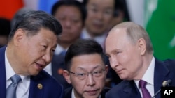 Chinese President Xi Jinping, left, and Russian President Vladimir Putin, right, speak during Outreach/BRICS Plus format session at BRICS Summit in Kazan, Russia, Oct. 24, 2024.