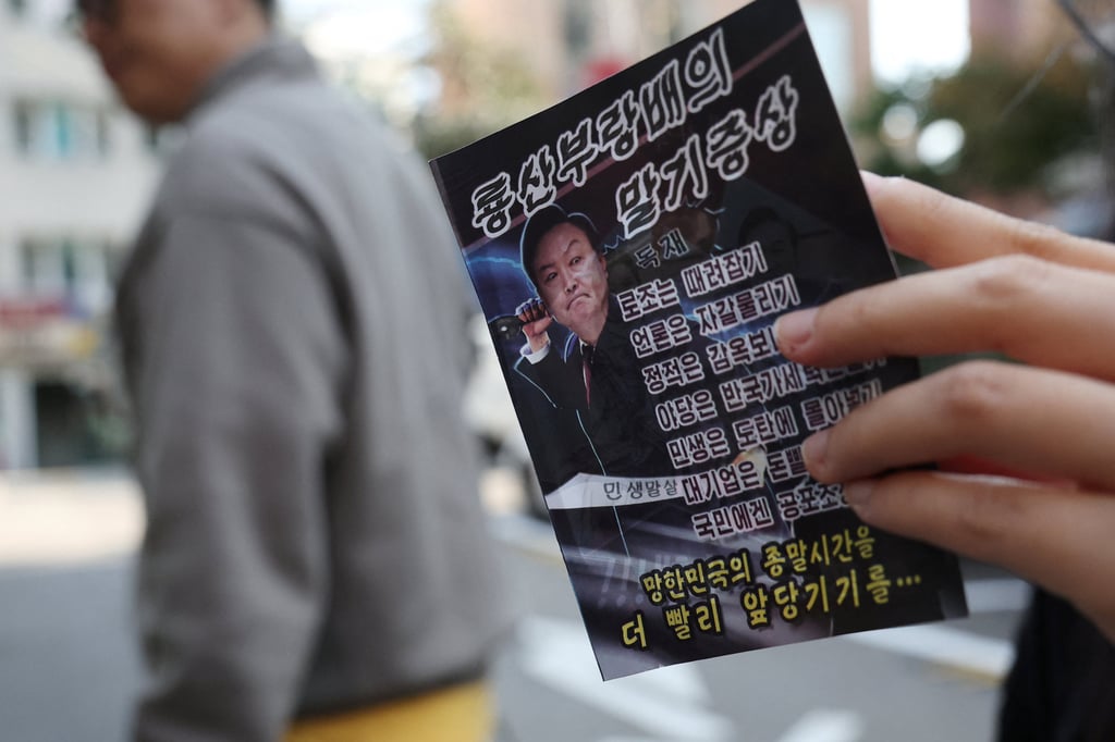 A woman in Seoul looks at a North Korean propaganda leaflet denouncing South Korean President Yoon Suk-yeol, apparently carried over the border by balloon last week. Photo: Reuters