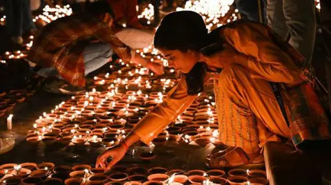 Getty Images People light earthen lamps on the banks of Sarayu river during a programme, on the eve of Diwali, on November 11, 2023, Ayodhya