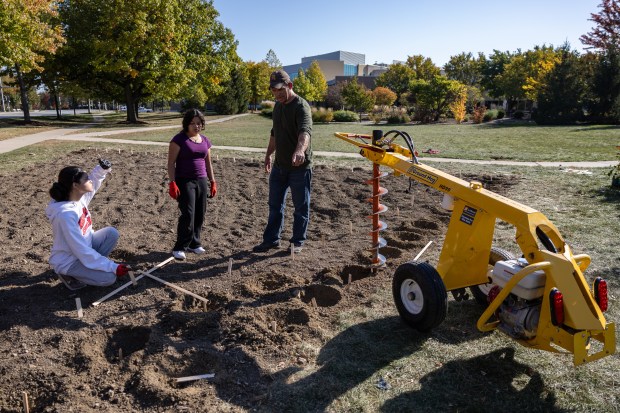 Naperville Central teacher Seth Brady, right, gives instructions to student...