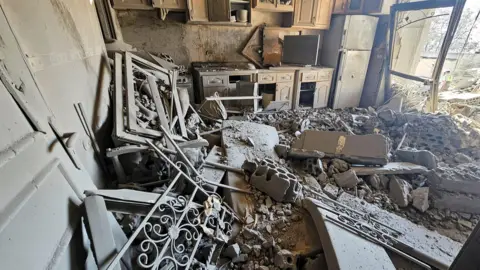 Reuters The inside of a damaged house shows a floor covered in rubble and dust after an Israeli strike