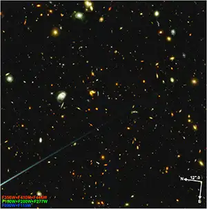 JWST NIRCam imaging of star-forming protocluster PHz G191.24+62.04, 11 billion years ago as the universe was approaching the peak of star formation. These early galaxies are among the most active star-forming galaxies observed between 10.5 and 11.5 billion years ago. Each galaxy seen in this image is therefore producing many black holes, which are converting matter into dark energy according to the cosmologically coupled black hole hypothesis. This image shows the two "modules" of JWST NIRCam: The leftmost module contains the protocluster, and the rightmost module is an adjacent blank field. Each module sees thousands of galaxies. Credit: NASA/IOP