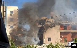 Smoke rises from a building hit by an Israeli airstrike, in the southern port city of Sidon, Lebanon, Oct. 27, 2024.