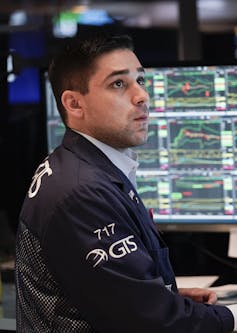 A trader sits at a computer at the New York Stock Exchange