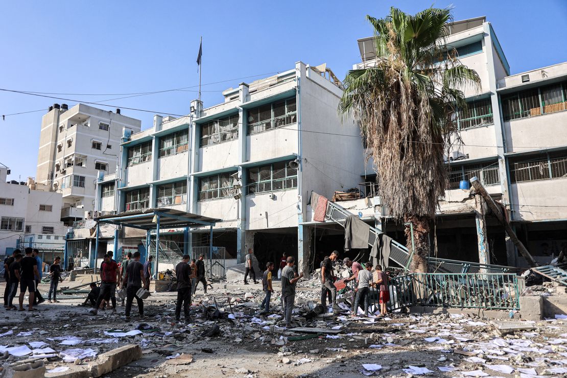 Men and children search through debris in the yard of the Asma school run by UNRWA, in the Shati camp for Palestinian refugees west of Gaza City, in the aftermath of overnight Israeli bombardment on June 25.