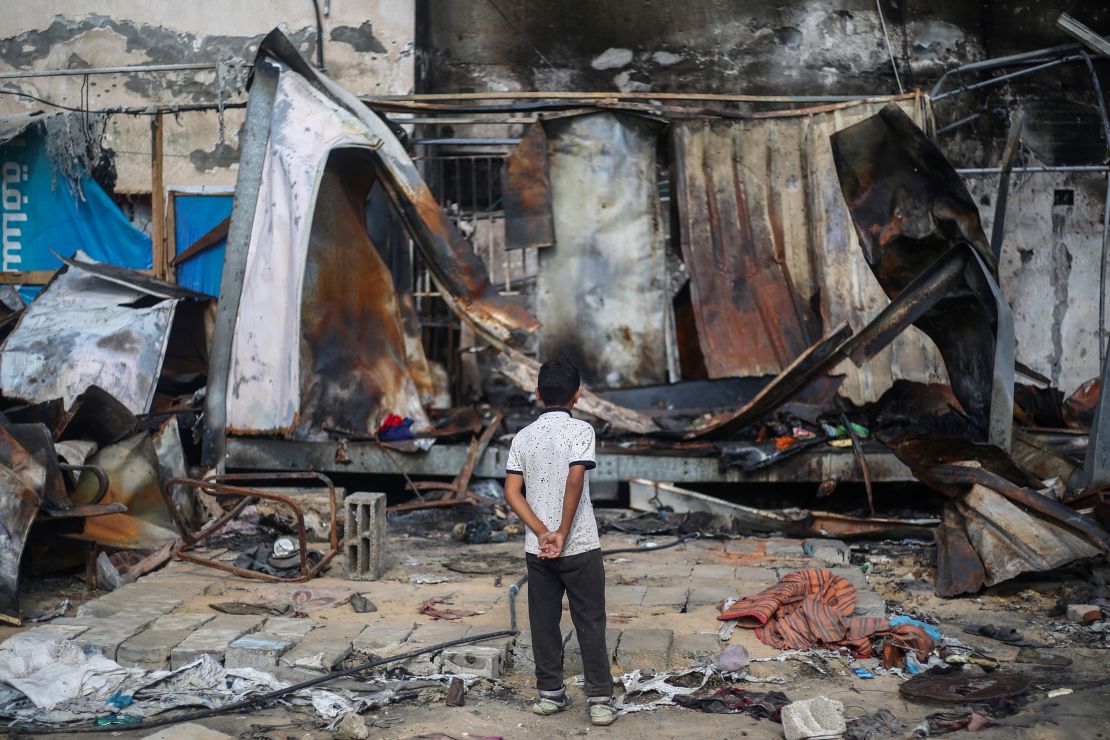 TOPSHOT - A Palestinian boy looks at destroyed shelters at the site of an Israeli airstrike which hit tents for displaced people two days earlier in the courtyard of Al-Aqsa Martyrs Hospital in Deir al-Balah in the central Gaza Strip on October 16, 2024. A spokesman for the Palestinian Civil Defence in Gaza said the October 14 strike had killed four people and wounded many more, noting it was the seventh time an attack had hit the 