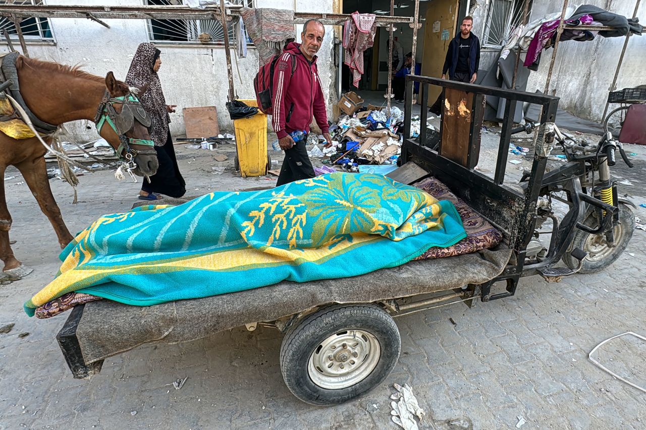 A body lies covered by a blanket on a cart outside the Kamal Adwan Hospital in Beit Lahiya, Gaza, following an Israeli strike on October 28.