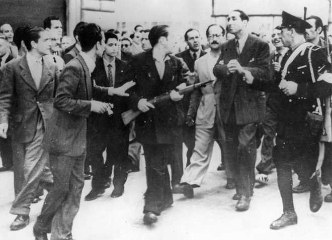 19th July 1944:  In Rome, an angry crowd of armed anti-Fascist civilians helps a  policeman escort an ex-'Big Shot' of the Fascists to the jail where he will be held until tried for crimes committed under the Mussolini regime.  (Photo by Keystone/Getty Images)