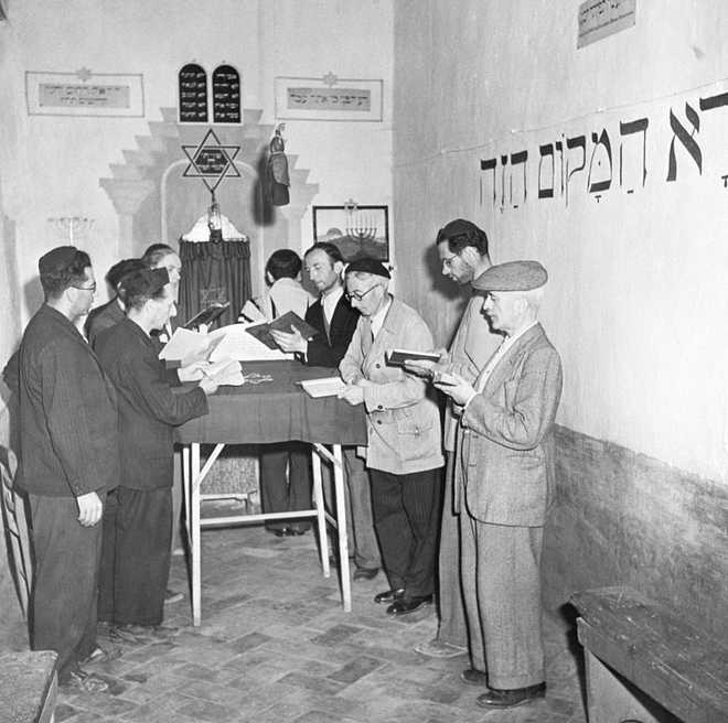 (Original Caption) 10/25/1943-Italy- Shown are men at prayer in the synagogue they made in the Italian Concentration Camp, Campagna, the first to be relieved by U.S. Forces. There are 150 male internees, mostly Jewish, who were awaiting visas and papers to permit passage to the U.S. when Italy declared war. They were thrown into this camp for three years until the Germans took the town. The internees took to the hills and came back when the U.S. troops took over.