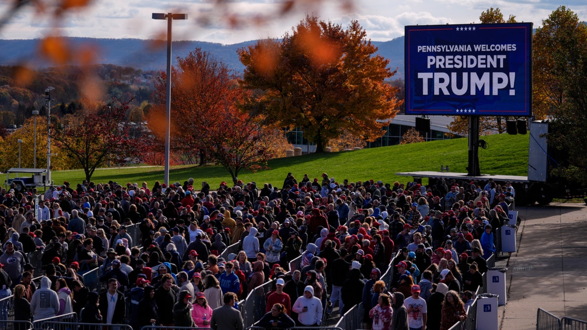 People wait in line to enter a Republican presidential nominee former President Donald Trump campaign event in State College, Pa., Saturday, Oct. 26, 2024.